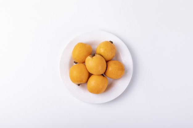 Free photo loquat fruits isolated on a white table