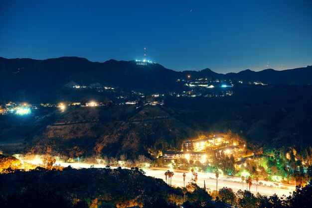 Лос-Анджелес ночью со знаком Голливуда и шоссе