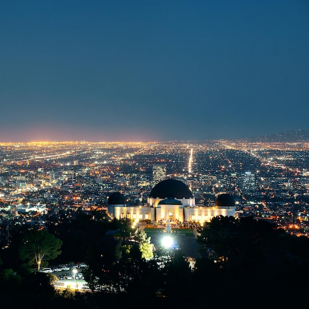 Los angeles di notte con edifici urbani e osservatorio griffith