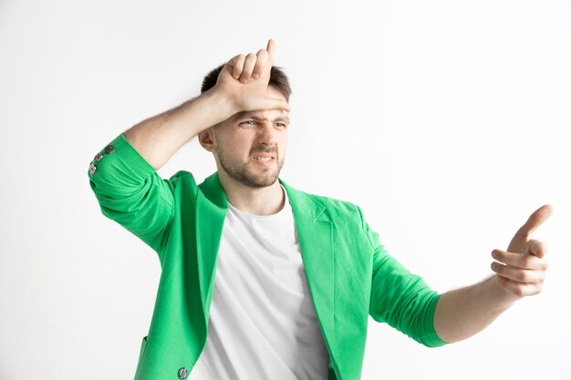 Free photo losers go home. portrait of happy guy showing loser sign over forehead