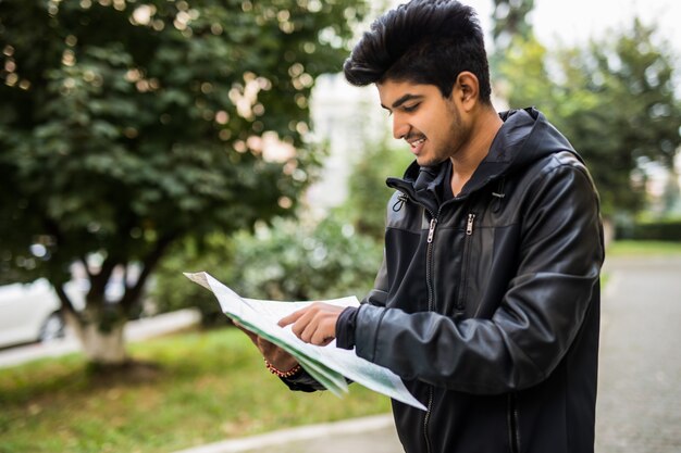 Lost indian tourist looking at city map on a trip