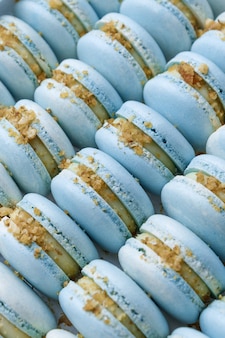A lot of blue macaroons lie in the package close-up.