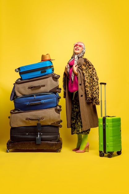 A lot of clothes for travel to go. caucasian woman's portrait on yellow space