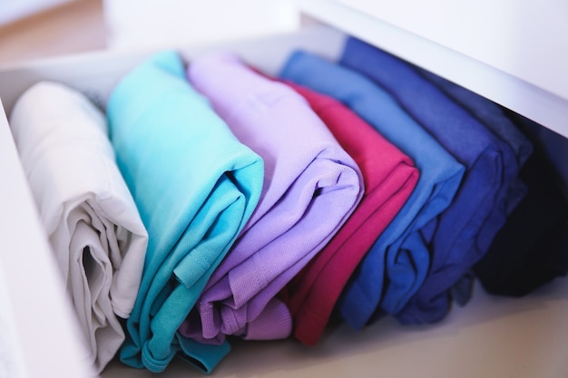 Lot of different folded clothes perfectly arranged in a closet - marie kondo konmari method concept
