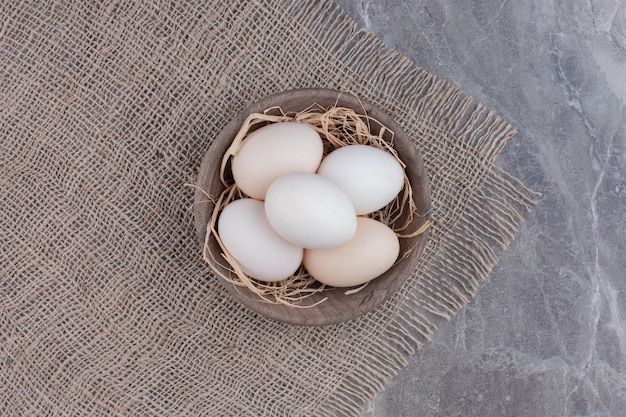 Free photo a lot of fresh chicken white eggs on wooden bowl. high quality photo