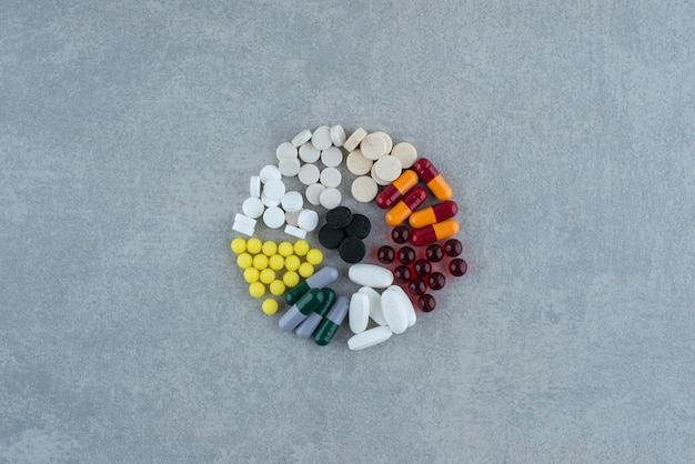 Много медицинских красочных таблеток на серой поверхности