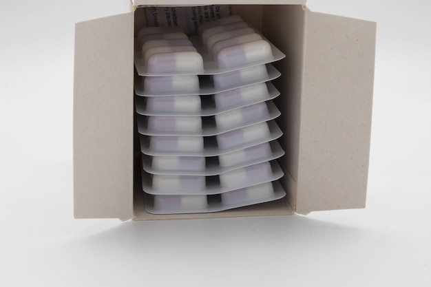 Lot of medical pills in a box on white