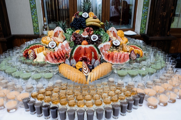 Бесплатное фото Много разнообразных фруктов и напитков подается на праздничный стол