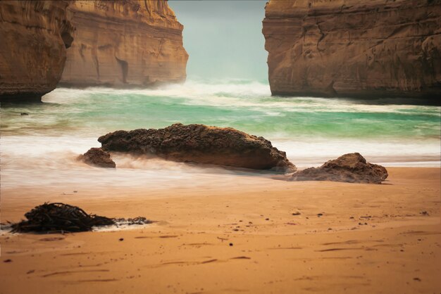 Lot of rock formations near the sea under the cloudy sky during daytime