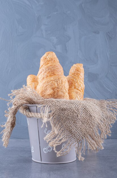 Lot of whole baked wholegrain croissant in basket .