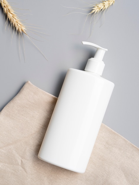 Free photo lotion bottle mock-up next to wheat