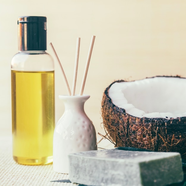 Lotion, coconut and vase with sticks