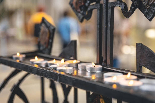 Много маленьких свечей в католической церкви