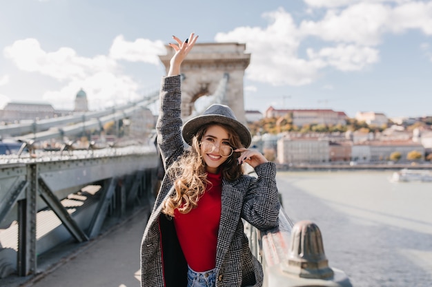 Lovable female tourist in elegant attire expressing happy emotions