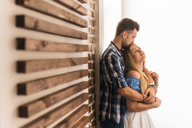 Lovable man kissing a woman at home