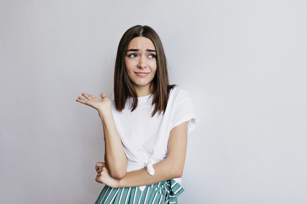 Lovable woman posing emotionally. Worried caucasian girl with brown hair standing.