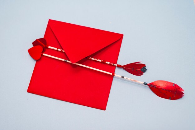 Love arrows with envelope on grey table