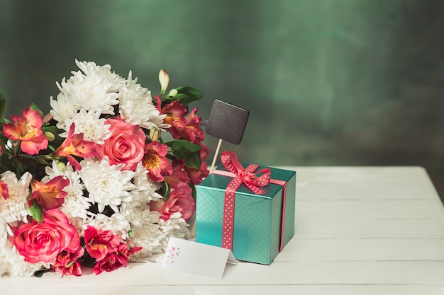 Love background with pink roses, flowers, gift on table