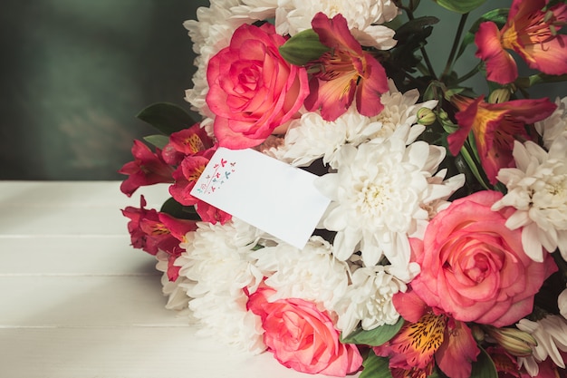 Love background with pink roses, flowers, gift on table