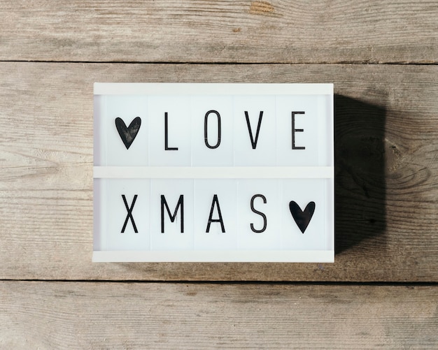Free photo love christmas text in led panel with wooden background