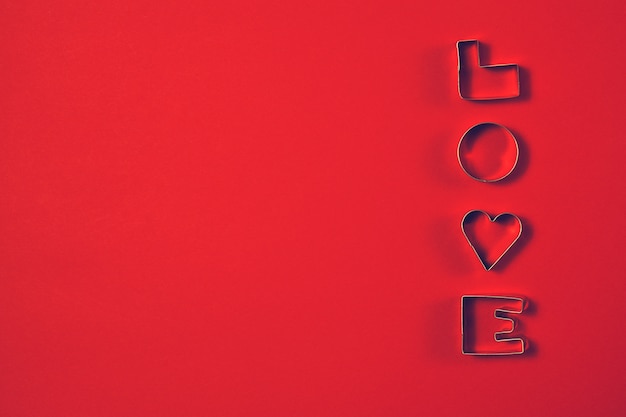 Free photo love concept with letters love on a red background. top view wit