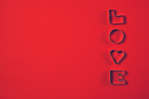 Love concept with letters LOVE on a red background. Top view wit