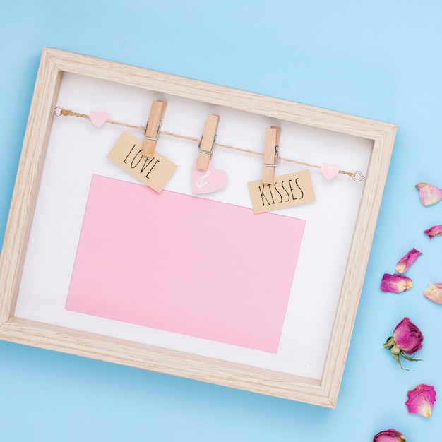 Free photo love and kisses inscription in frame with flower petals