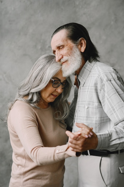 Love never grows old. Joyful active old retired romantic couple dancing in living room.