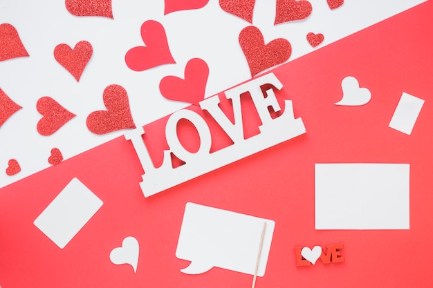 Love title near paper and ornament hearts 
