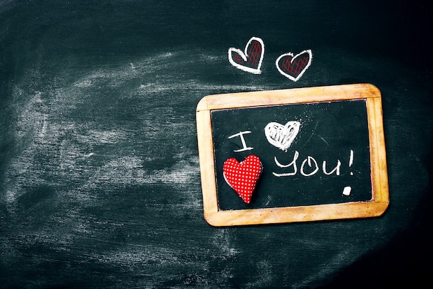 Free photo love or valentine's day concept with chalkboard and hearts on a