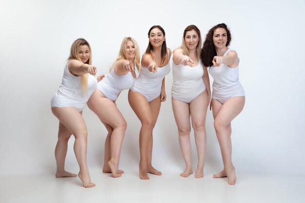 In love with myself. Portrait of beautiful plus size young women posing on white