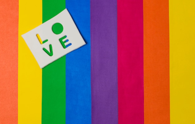 태블릿 및 밝은 LGBT 깃발에 사랑 단어