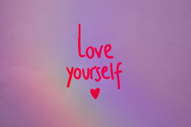 Love yourself inscription on purple paper 