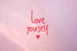 Free photo love yourself inscription on purple table