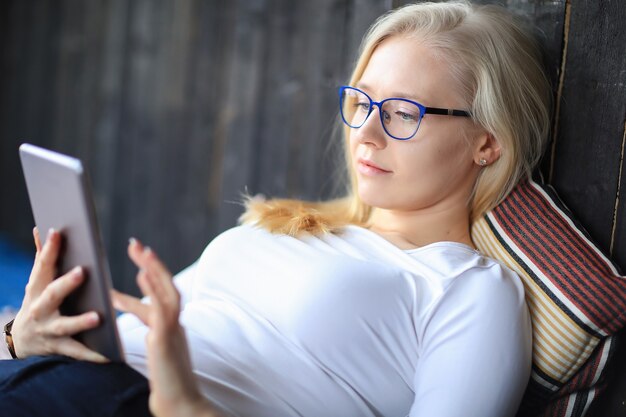 Lovely blonde woman with eyeglasses posing in white shirt