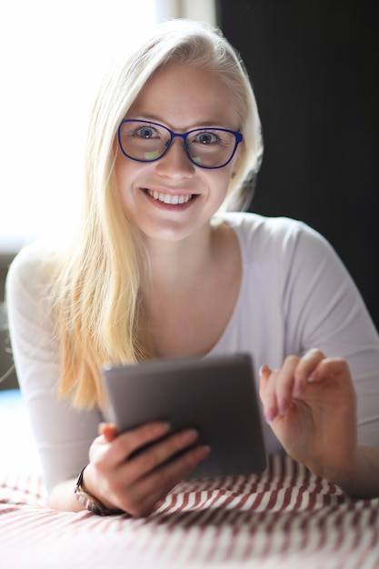 Lovely blonde woman with eyeglasses posing in white shirt