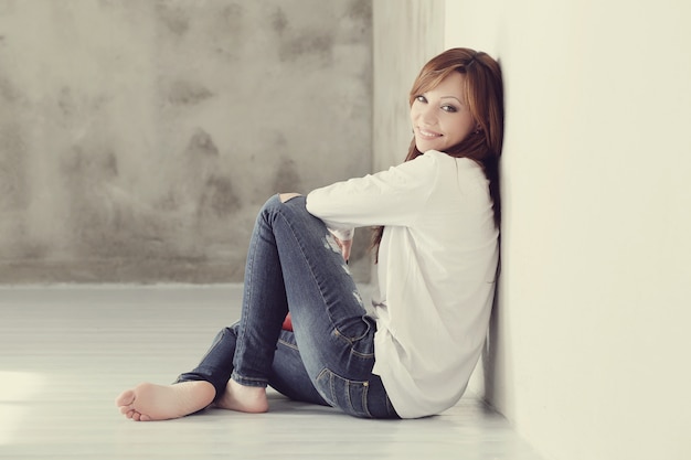 Free photo lovely and charming adult woman sitting on floor