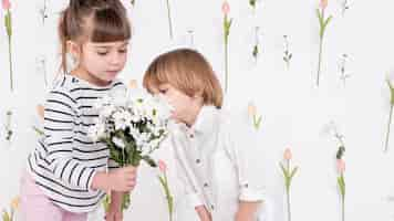 Free photo lovely children looking at flower bouquet