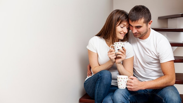 無料写真 コーヒーを飲みながら階段に座って素敵なカップル