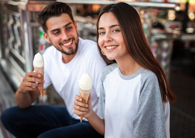 フェアでアイスクリームを食べる素敵なカップル