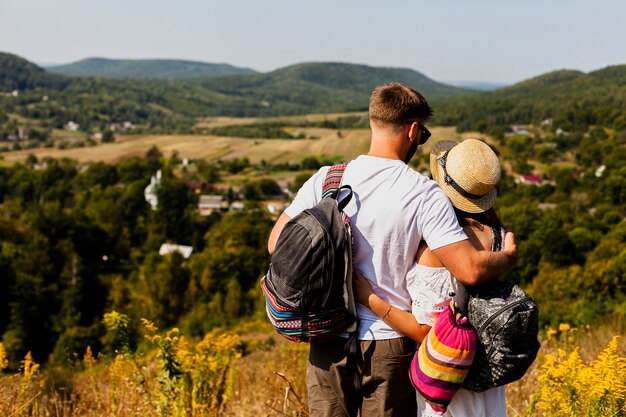 Lovely couple hugging each other and looking at the forest