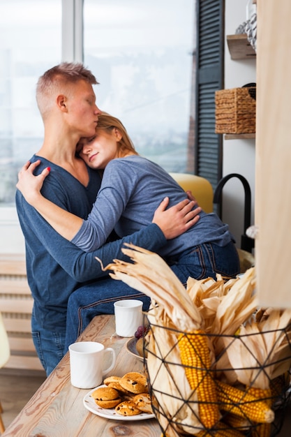 Foto gratuita bella coppia abbracciarsi in cucina