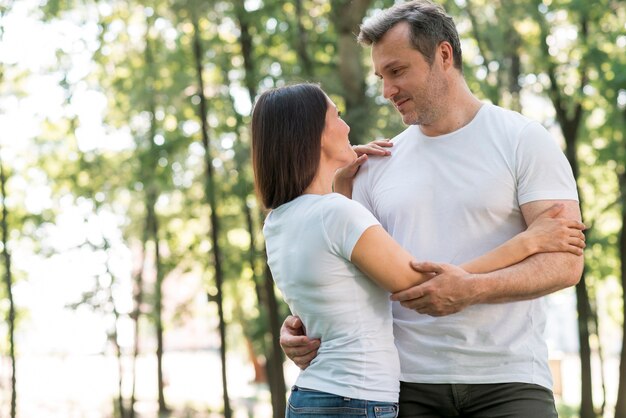 Lovely couple hugging and looking at each other in park