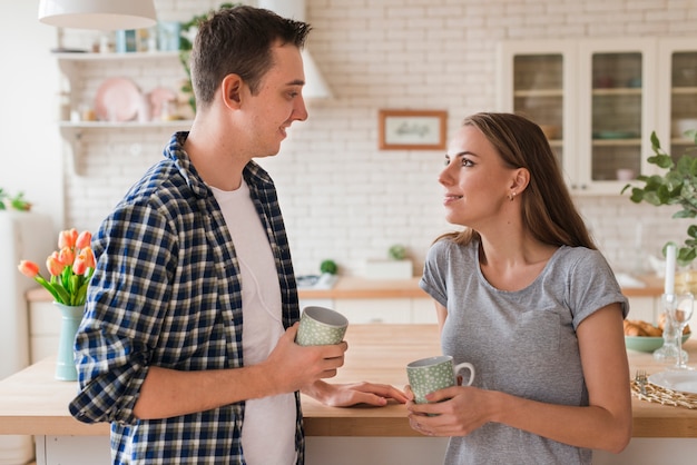 テーブルに寄りかかってお茶を楽しんで素敵なカップル