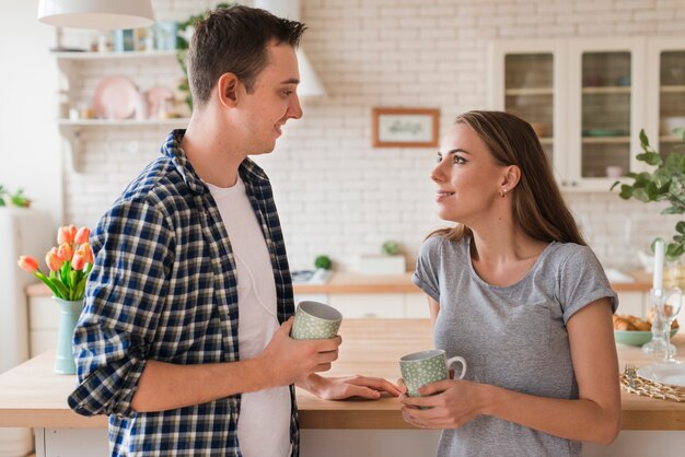 Lovely couple leaning on table and relishing tea