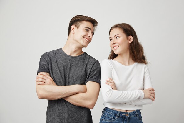 Lovely couple looking at each other with crossed hands while smiling.