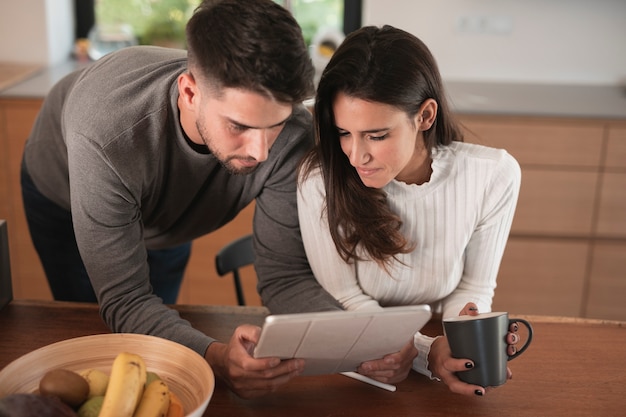 Free photo lovely couple looking at tablet