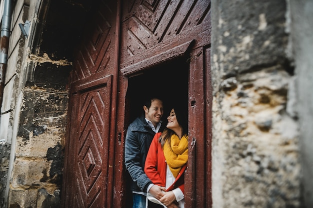 The lovely couple in love embracing near door