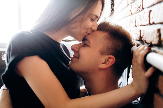 Free photo the lovely couple in love embracing and sitting on the bed