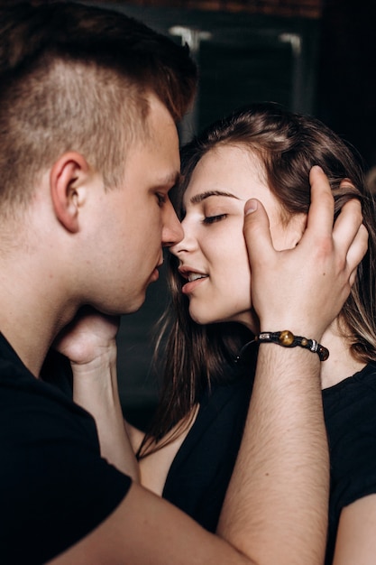 The lovely couple in love embracing and sitting on the bed